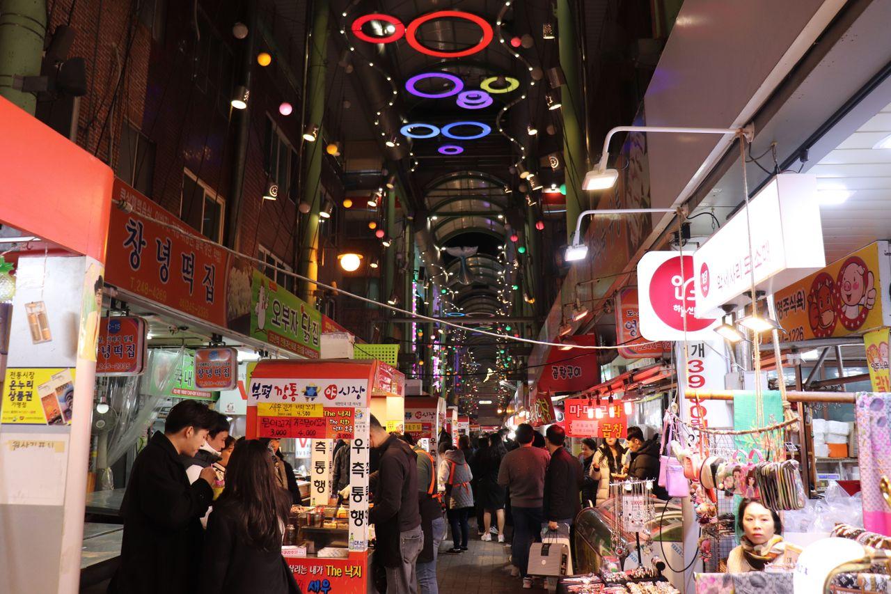 富平市場內部亮麗的燈光設計，街道上人群熙攘